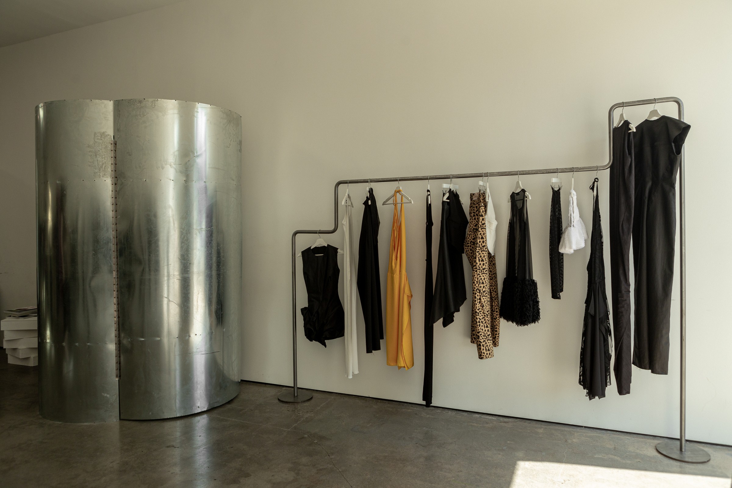 Garment rack against a curved galvanized steel wall